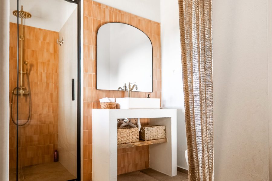 Baño con ducha y lavabo sobre encimera de madera