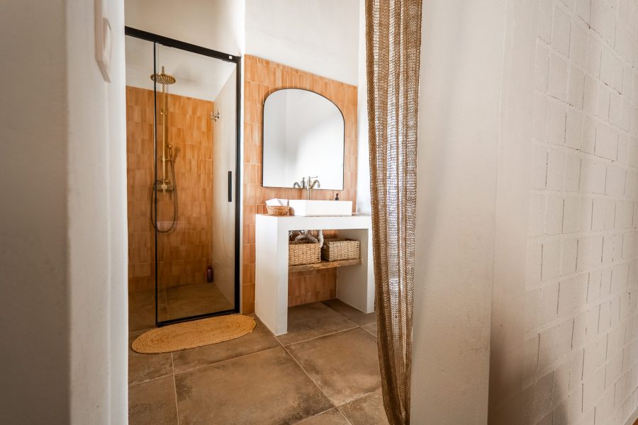 Baño con espejo de arco y lavabo de obra