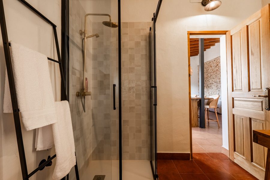 Baño con ducha de obra y mampara negra