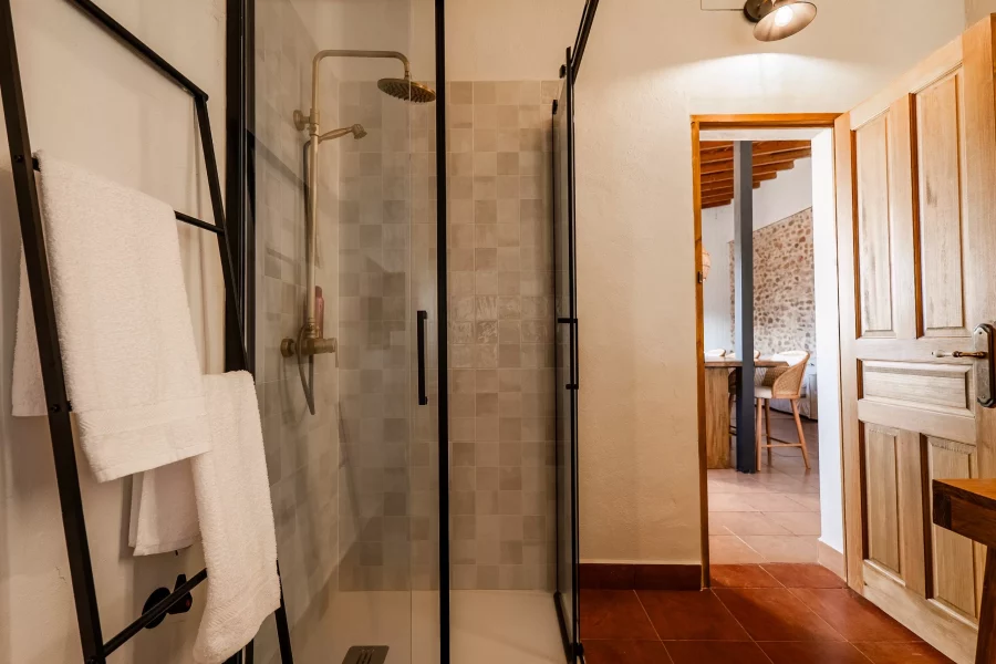 Baño con ducha de obra y mampara negra