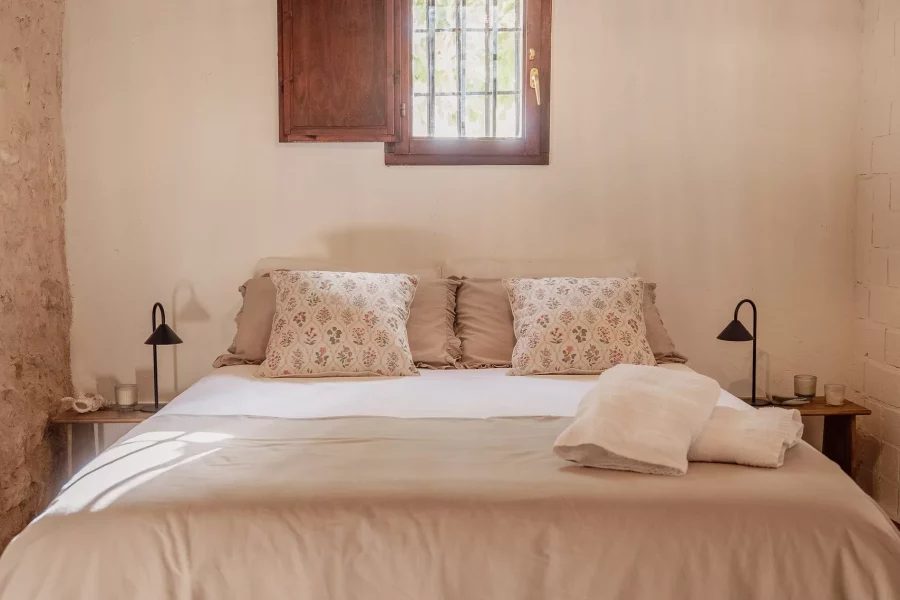 Dormitorio con lámpara de araña y ventana de madera