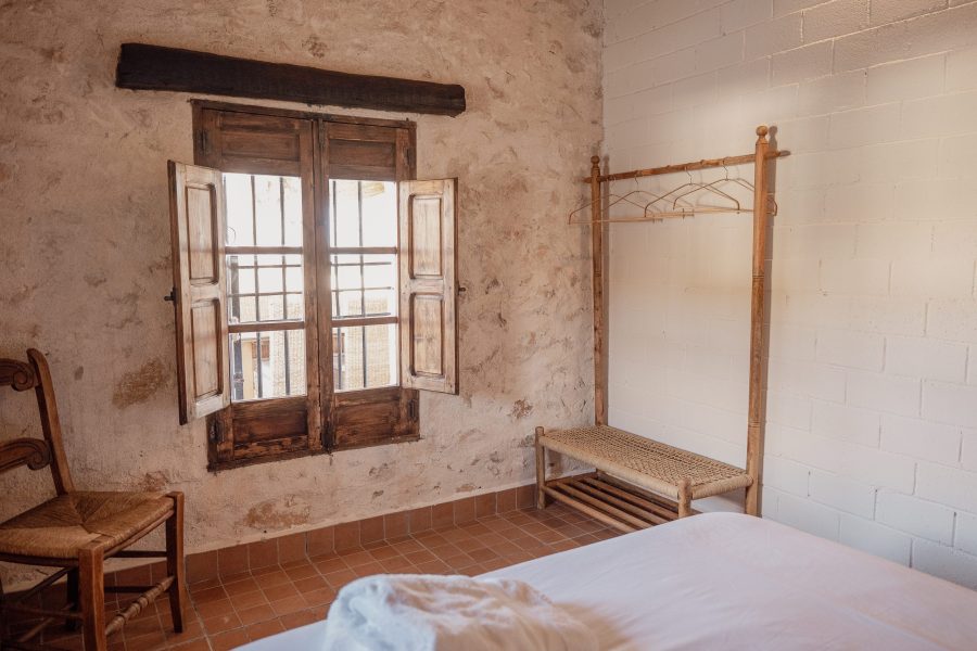 Dormitorio con cama de dosel junto a la ventana