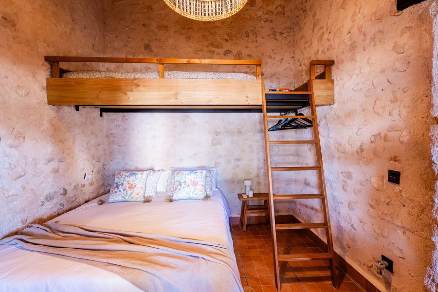 Dormitorio con cama de matrimonio y litera alta de madera