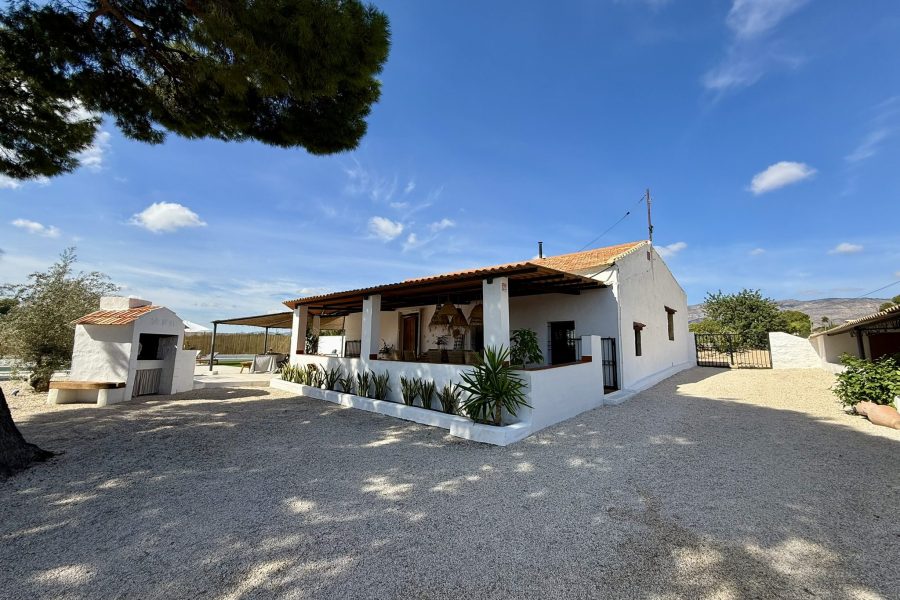 Fachada blanca de la casa entre los árboles