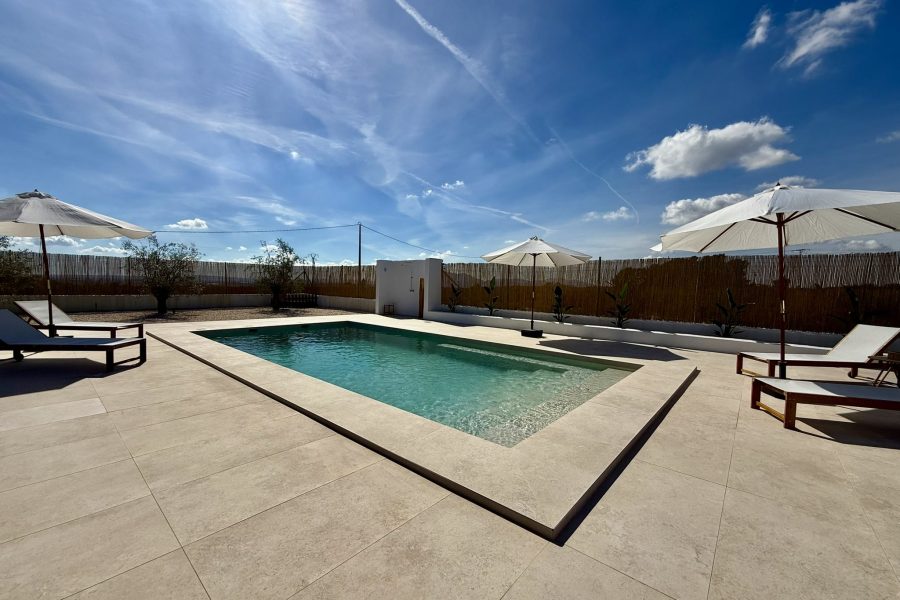 Piscina exterior con tumbonas y sombrillas