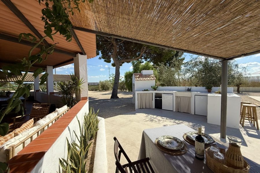 Porche cubierto con mesa y zona de comedor exterior