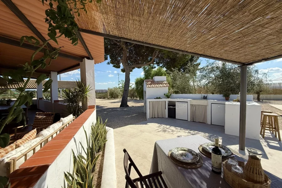 Porche cubierto con mesa y zona de comedor exterior