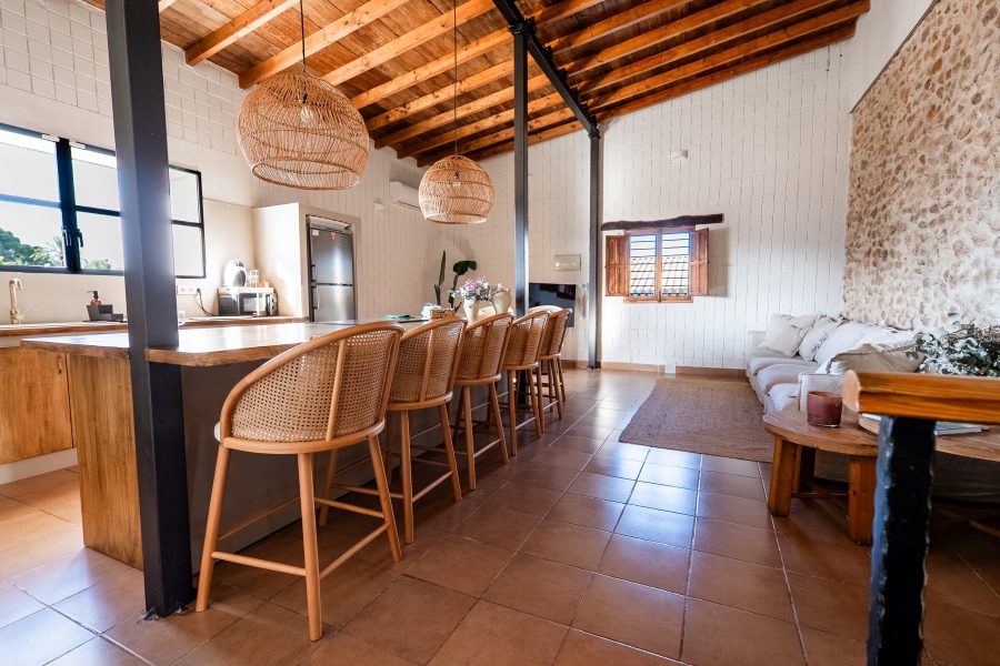 Barra de la cocina con taburetes de mimbre y lámparas colgantes